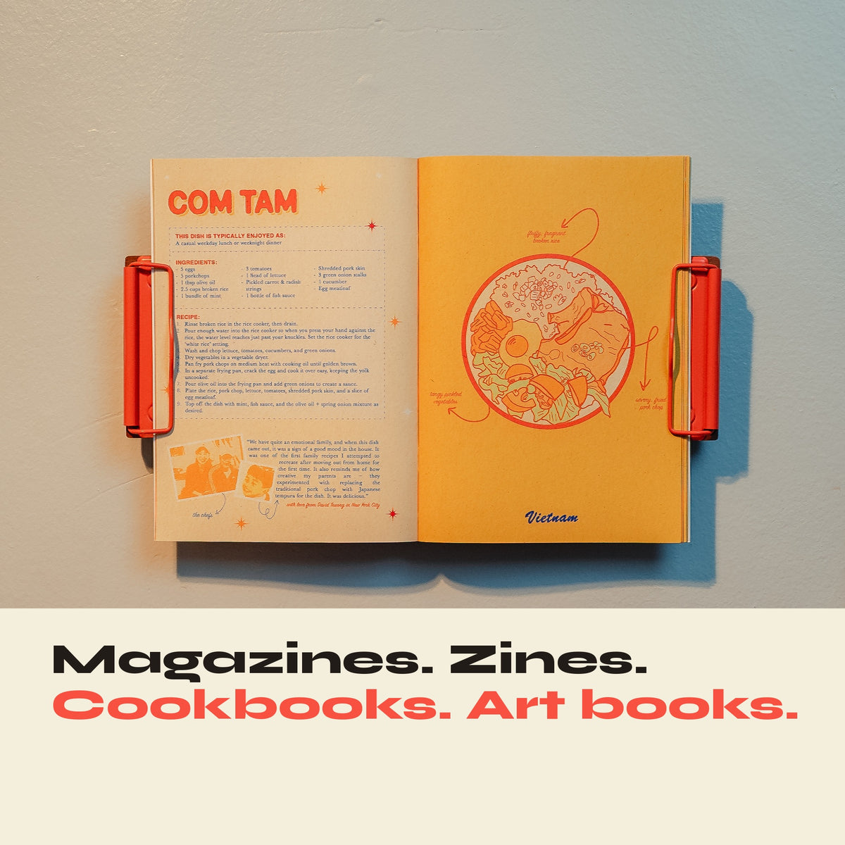 Open cookbook displayed on a wall with red-orange FORMA clips