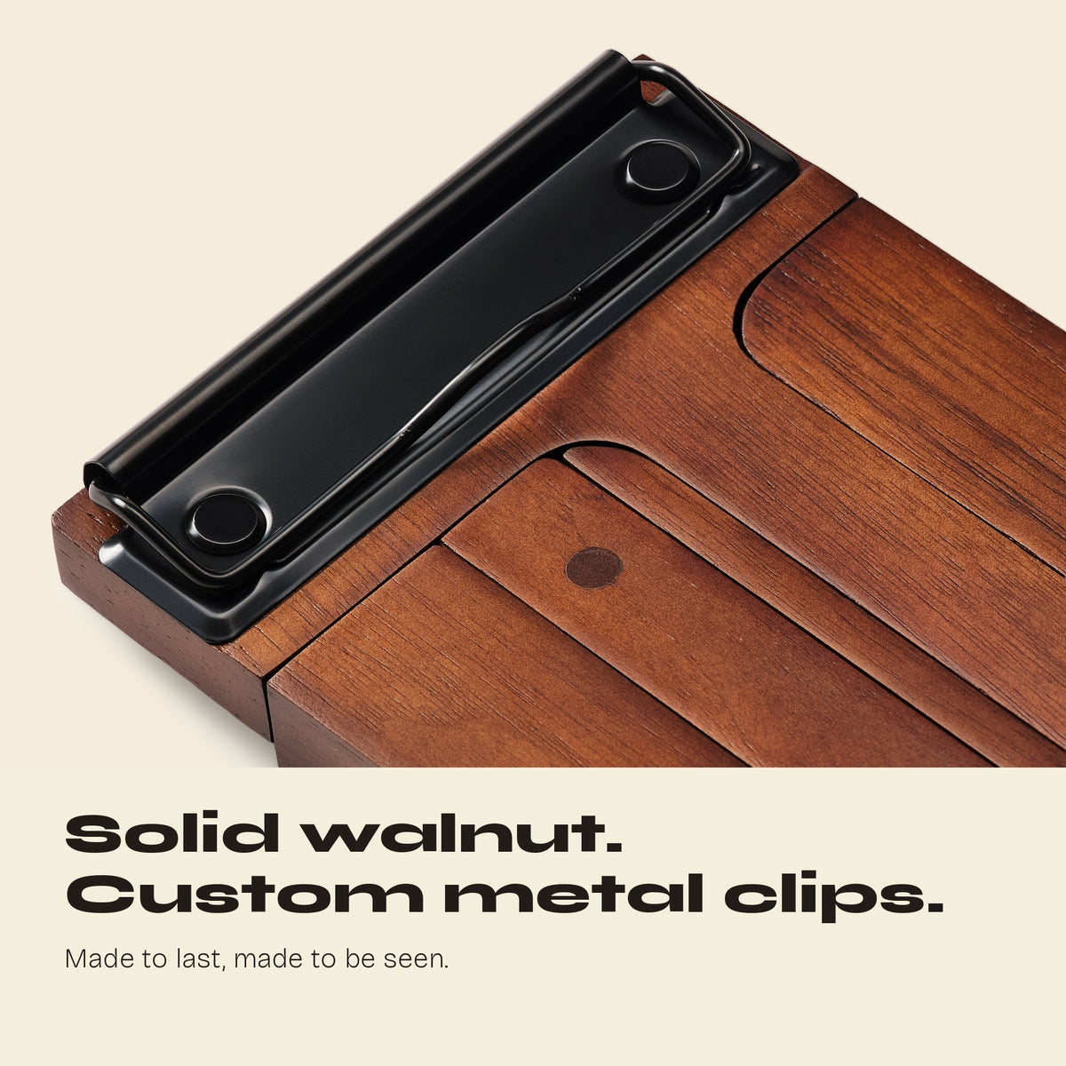 Close-up of a black metal clip on a solid walnut FORMA display